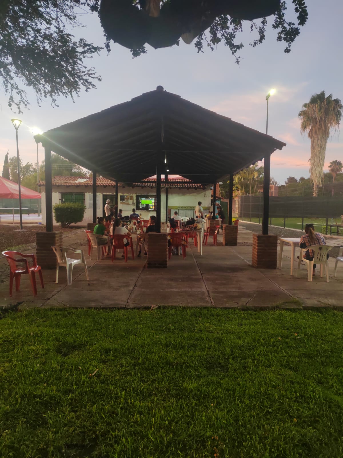 Zona de descanso con palapa junto a las canchas